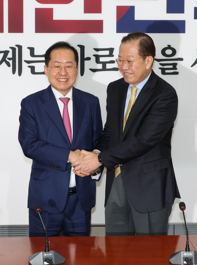 홍준표(왼쪽) 전 대구시장이 14일 오전 서울 여의도 국회에서 권영세 국민의힘 비상대책위원장과 두 손을 맞잡고 사진촬영을 하고 있다. 박윤슬 기자