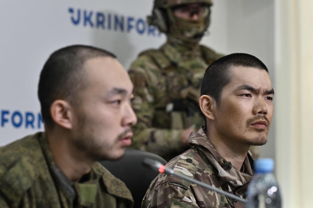 우크라이나의 포로가 된 중국인 러시아 용병 장런보(좌측)와 왕광쥔(우측)이 14일 우크라이나 보안국 주최로 열린 기자회견에서 질문을 받고 있다. AFP 연합뉴스