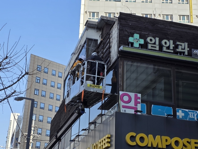 서울 금천구 관내에서 정비가 필요한 벽면 간판을 점검하고 있다. 금천구청 제공