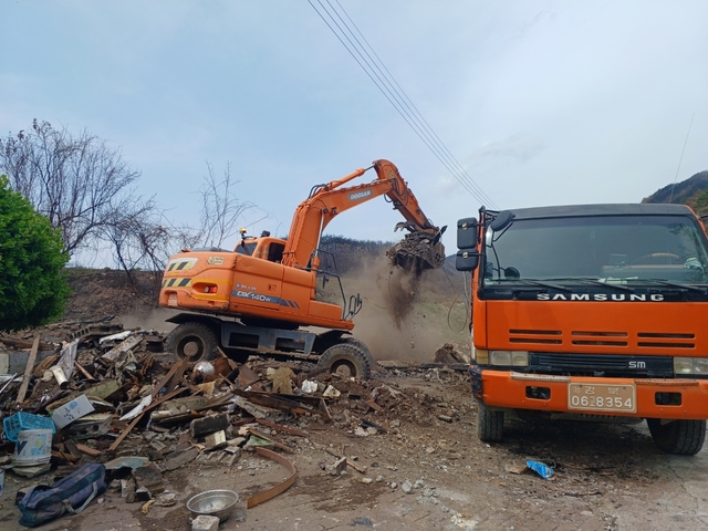 17일 경북 영덕군 지품면에서 임시주택 조성 등을 위해 포클레인으로 산불에 탄 주택 잔해물을 치우는 작업이 진행되고 있다.