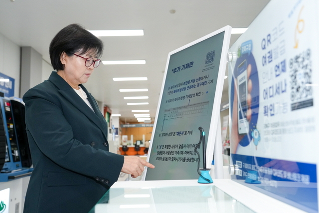 이순희 강북구청장이 강북구청사 1층 민원실에 게시된 여권 발급 안내 디지털 사이니지를 이용하고 있다.강북구청 제공
