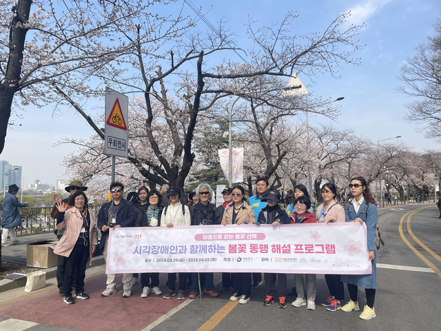 서울 영등포구의 봄꽃 동행 무장애 해설 관광 프로그램에 참여한 시각 장애인들이 기념촬영을 하고 있다. 영등포구청 제공
