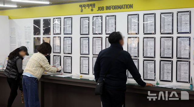 지난 9일 서울 마포구 서부고용복지플러스센터에서 직원이 구인정보를 교체하고 있는 가운데 구직자가 일자리 정보 게시판을 살펴보고 있다. 뉴시스