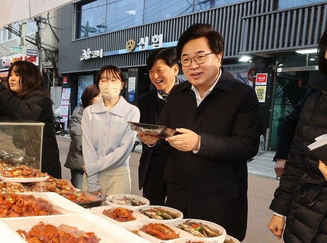 박일하(오른쪽) 서울 동작구청장이 지난 1월 성대시장에서 설 명절을 맞아 장을 보고 있다. 동작구청 제공