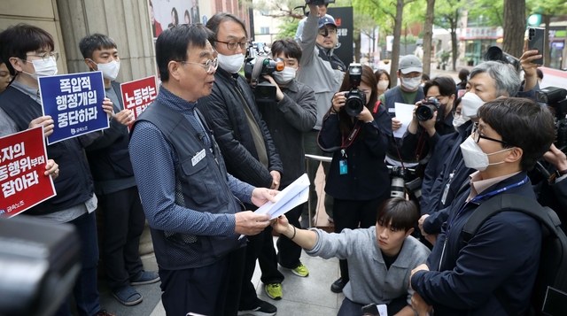 2023년 4월 서울 중구 정동 금속노조 입구에서 고용노동부 관계자들이 회계 자료 미제출 노조 현장조사에 착수한 가운데 금속노조 관계자들이 현장 조사를 거부하고 있다. 뉴시스.