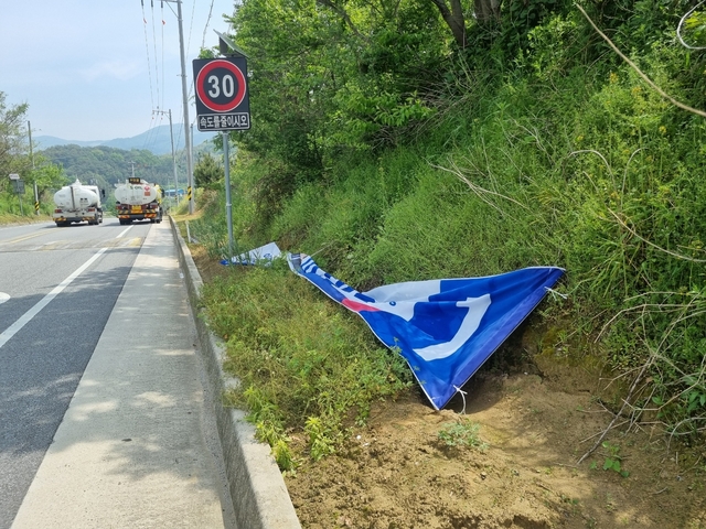 줄이 끊어져 땅위 뒹굴고 있는 이재명 더불어민주당 대통령 후보 플래카드. 민주당 제공