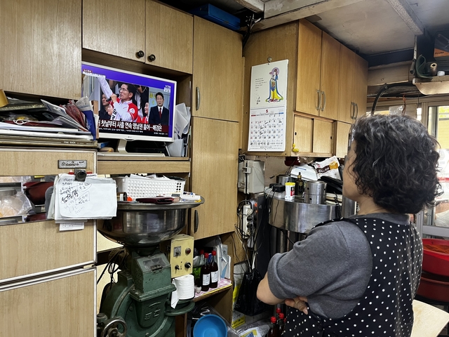 14일 경남 양산시 덕계종합상설시장에서 한 상인이 가게 안에서 대통령 선거 관련 뉴스를 시청하고 있다.