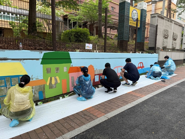 지난 17일 한국앤컴퍼니그룹이 진행한 ‘벽화 그리기’ 봉사활동에서 그룹 임직원이 가족과 함께 벽화를 그리고 있다. 한국앤컴퍼니그룹 제공.