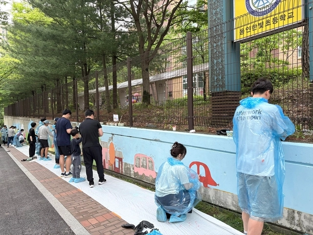 지난 17일 한국앤컴퍼니그룹이 진행한 ‘벽화 그리기’ 봉사활동에서 그룹 임직원이 가족과 함께 벽화를 그리고 있다. 한국앤컴퍼니그룹 제공.
