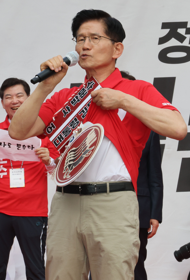 김문수 국민의힘 대선 후보가 22일 경기 광명시 철산로데오거리에서 열린 유세에 참석해 웃옷을 들어 보이며 방탄복을 입지 않았다고 말하고 있다. 연합뉴스