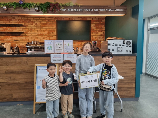 경기 시흥시 배곧동 13 일원 학교복합시설 배곧너나들이센터에서 어린이들이 폐건전지 수거함을 들고 사진을 찍고 있다. 시흥시청 제공