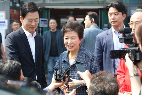 박근혜 전 대통령이 제21대 대통령선거 사전투표 첫날인 29일 대구 달성군 유가읍행정복지센터에 마련된 사전투표소에서 투표 후 취재진의 질문에 답하고 있다. 사진 왼쪽은 유영하 국민의힘 의원. 연합뉴스