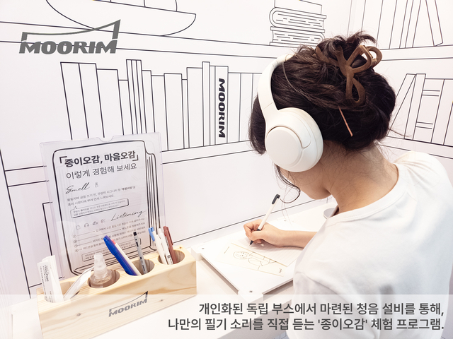 무림이 오는 22일까지 서울 코엑스에서 열리는 ‘2025 서울국제도서전’에 마련한 체험형 전시관에서 모델이 종이에 글을 쓰는 소리를 듣는 체험을 하고 있다.