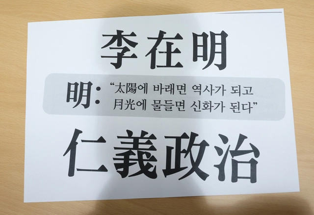 이규연 홍보소통수석이 11일 용산 대통령실 기자회견장에서 이재명 대통령과 정규재 전 한국경제신문 주필, 조갑제 ‘조갑제닷컴’ 대표의 오찬 회동 브리핑 전 나눠준 종이. ‘태양에 바래면 역사가 되고 월광에 물들면 신화가 된다’와 ‘이재명 인의정치’가 적혀있다. 이 수석은 오찬 회동 중 조갑제 대표가 소개한 소설가 이병주의 글귀라고 전했다. 연합뉴스