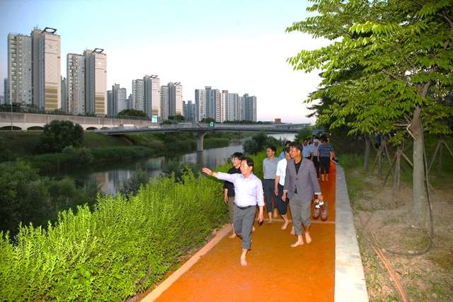 주광덕(맨 앞) 남양주시장과 지역 도의원이 진접읍 장현리 일원에 새롭게 조성한 장현공원 내 ‘왕숙천 테마정원’에서 시민과 함께 맨발 걷기 길을 체험하고 있다. 남양주시 제공