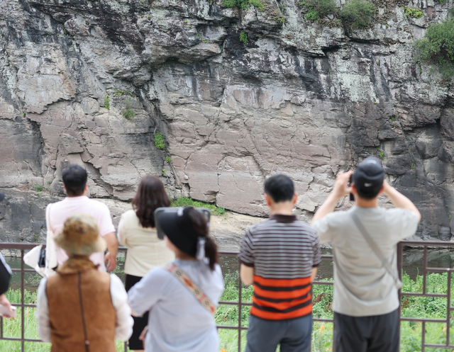 13일 울산시 울주군 대곡리 반구대 암각화 전망대에서 시민이 망원경으로 암각화를 관람하고 있다. 연합뉴스