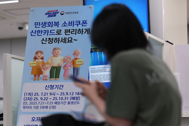이재명 정부의 첫 대규모 경기 부양책인 ‘민생회복 소비쿠폰’ 신청이 시작된 21일 서울 시내 한 은행에 관련 배너가 설치돼 있다. 연합뉴스