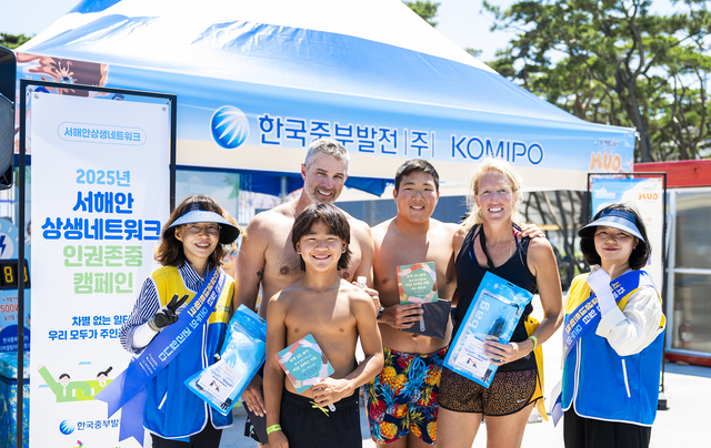 5일 서해안상생네트워크 관계자들이 보령 머드축제 관광객들에게 기념품을 배부하고 있다. 한국중부발전 제공