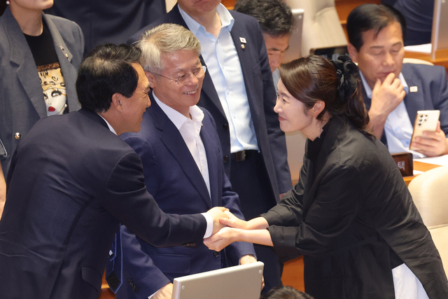 여성가족부 장관에 낙마한 더불어민주당 강선우 의원이 5일 국회 본회의에 출석해 방통법 개정안에 투표한 뒤 박수현 의원 등과 악수하고 있다.  연합뉴스