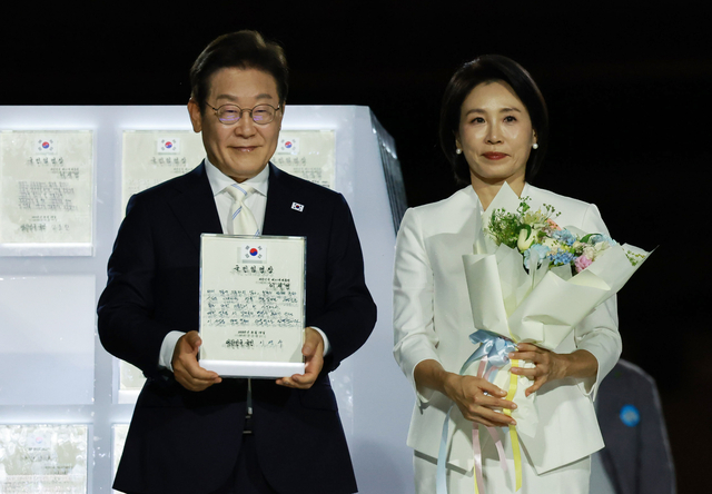 이재명 대통령과 김혜경 여사가 15일 서울 세종대로 광화문광장에서 열린 제21대 대통령 국민임명식 ‘광복 80년, 국민주권으로 미래를 세우다’ 행사에서 국민 대표 80인으로부터 ‘빛의 임명장’을 받은 뒤 감사 인사를 하고 있다. 연합뉴스