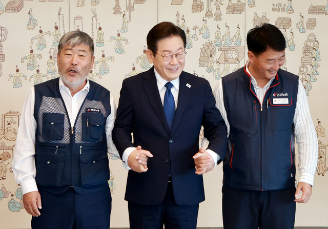 이재명 대통령이 4일 서울 용산 대통령실 청사에서 열린 양대노총 위원장과의 오찬 간담회에 참석해 김동명 한국노총 위원장(왼쪽), 양경수 민주노총 위원장과 기념촬영을 하며 손을 잡고 있다. 연합뉴스