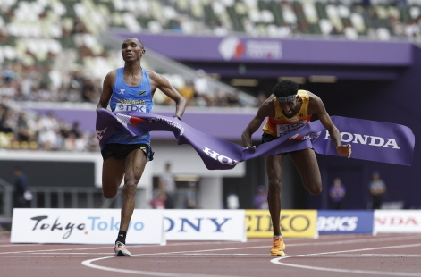 탄자니아의 알폰스 필릭스 심부(왼쪽)과 독일의 아마날 페트로스(독일)가 15일 일본 도쿄 국립경기장에서 세계육상선수권대회 남자 마라톤 결승선을 나란히 통과하고 있다. EPA 연합뉴스