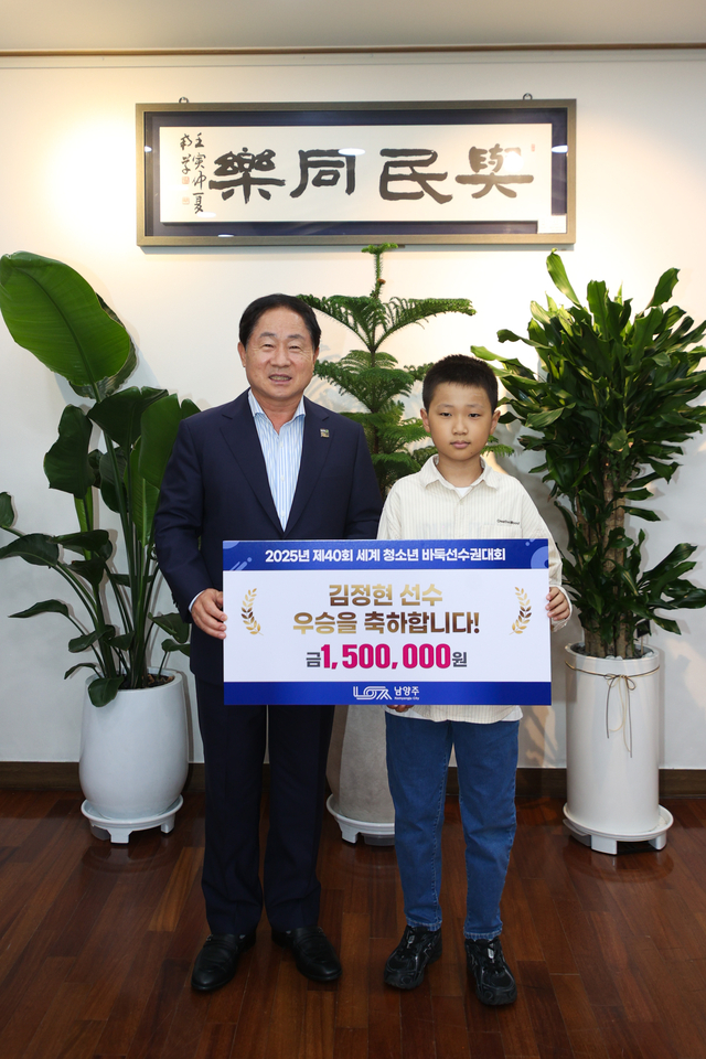 주광덕 남양주시장이 제40회 세계 청소년 바둑선수권대회 주니어부(U-12)에서 우승을 차지한 김정현 선수에게 포상금 150만 원을 전달 후 기념촬영을 하고 있다. 남양주시 제공