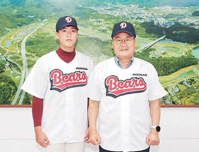 최명서(오른쪽) 영월군수와 올해 신인드래프트에서 두산에 지명된 상동고 투수 임종훈이 지난 23일 강원 영월군 영월읍의 영월군청 군수실에서 두산 유니폼을 입고 기념촬영을 하고 있다.  영월군청 제공 