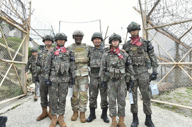진영승 합참의장과 제이비어 브런슨 주한미군사령관이 3일 전방소초(GP)·일반전초(GOP)  현장점검을 마치고, 장병들의 목에 한미동맹의 캐치프레이즈인 ‘We go Together(같이 갑시다)’가 새겨진 머플러를 걸어주고 포즈를 취하고 있다. 합참 제공