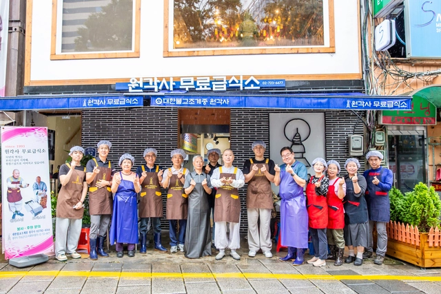 28일 원각사 무료급식소에서 봉사활동을 한 봉사자들이 기념사진을 촬영하고 있다. 이수복 작가