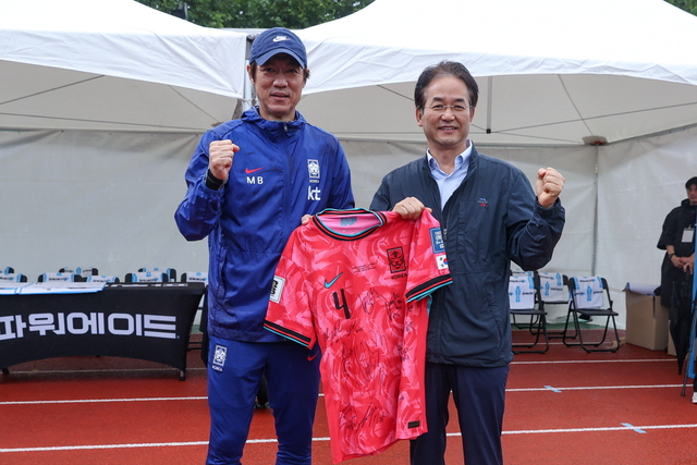 국가대표팀 선수들의 친필 사인 유니폼을 들고 기념촬영 중인 이동환 고양특례시장(오른쪽)과 홍명보 축구 국가대표팀 감독. 고양시 제공