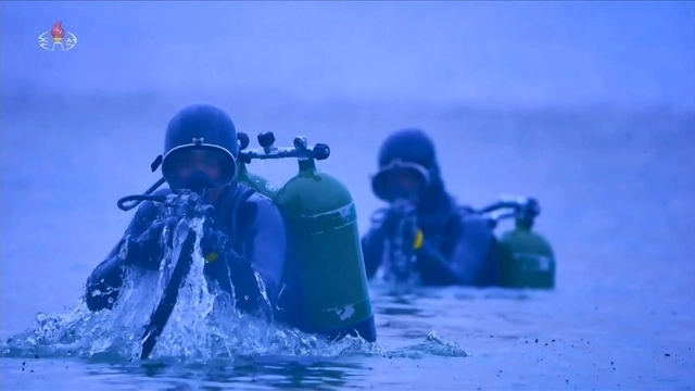 지난 10일 평양 김일성광장에서 열린 북한 조선노동당 창건 80주년 경축 열병식에서 특수부대가 훈련하는 모습을 담은 영상이 상영됐다. 군인들이 잠수함에서 빠져나와 잠수복 차림으로 사격 준비를 하고 있다 . 조선중앙TV 캡처/연합뉴스