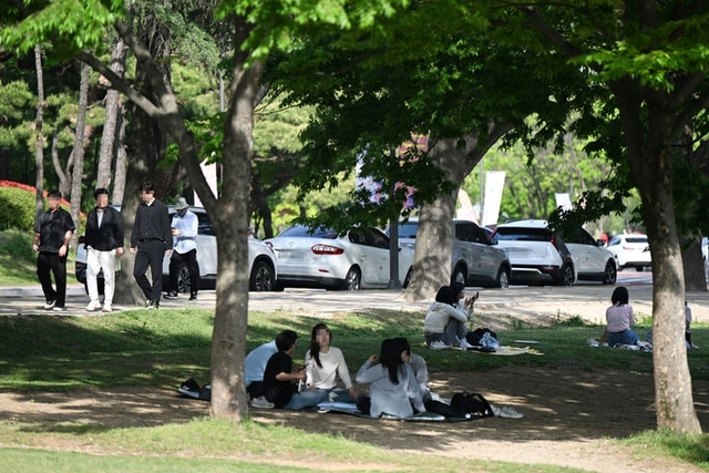 광주 북구 용봉동 전남대학교 캠퍼스에서 시민들이 잔디밭 그늘에 앉아 더위를 피하고 있다. 뉴시스