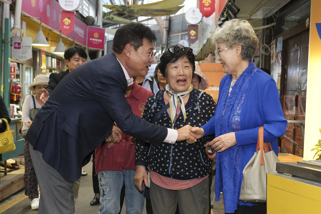 정문헌(왼쪽) 서울 종로구청장이 지난달 29일 추석을 앞두고 통인시장에서 주민들과 반갑게 인사하고 있다.  종로구청 제공