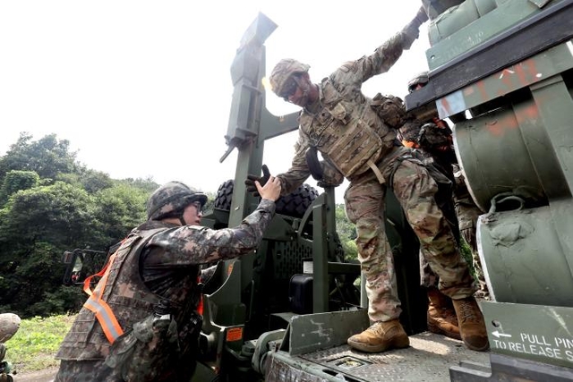 지난 8월25일 육군1군수지원여단에서 열린 전시 대화력전 대비 탄약 보급훈련에서 한미 장병들이 힘을 합쳐 PLS 차량에 오르고 있다. 국방일보 제공