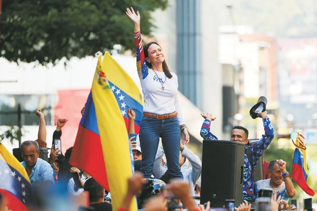 지난 1월 9일 베네수엘라 카라카스에서 열린 반정부 집회에서 야권 지도자 마리아 코리나 마차도가 소매에 베네수엘라 국기가 그려진 티셔츠를 입고 지지자들에게 손을 들어 인사하고 있다.  EPA 연합뉴스