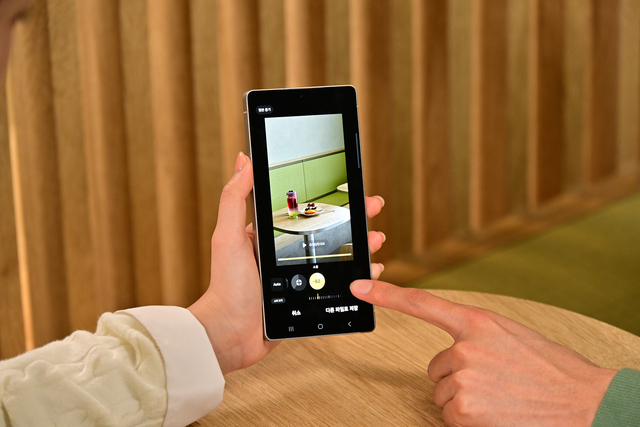 한 사용자가 삼성 갤럭시 스마트폰으로 ‘오디오 지우개’ 기능을 이용하고 있다. 갤럭시 오디오 지우개는 인공지능(AI)을 기반으로 동영상 속 소리를 음성·음악·바람·자연·군중·소음 등 6가지 유형으로 분석하고 분리해 원하는 대로 편집할 수 있도록 돕는다.  삼성전자 제공