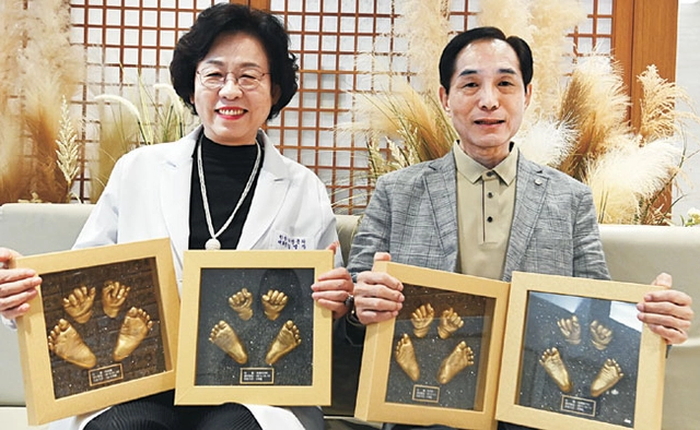 황경식 서울대 명예교수와 부인인 국내 1호 여성 한의원 박사인 강명자(왼쪽) 꽃마을한의원 대표원장이 지난달 30일 한의원에서 치료한 아이들의 손발을 본뜬 동판을 들고 있다. 곽성호 기자