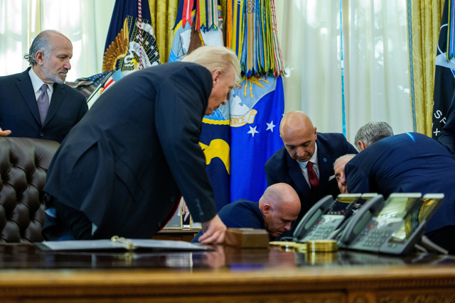 도널드 트럼프 미국 대통령이 6일 워싱턴DC 백악관 집무실에서 연설 도중 자신의 뒤에 시립해 있던 관계자가 쓰러지자 자리에서 일어나 응급처치 과정을 지켜보고 있다. UPI 연합뉴스