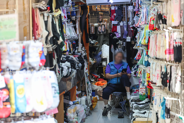 서울 중구 명동 거리 내 한 매장에서 한 상인이 손님을 기다리고 있다. 뉴시스