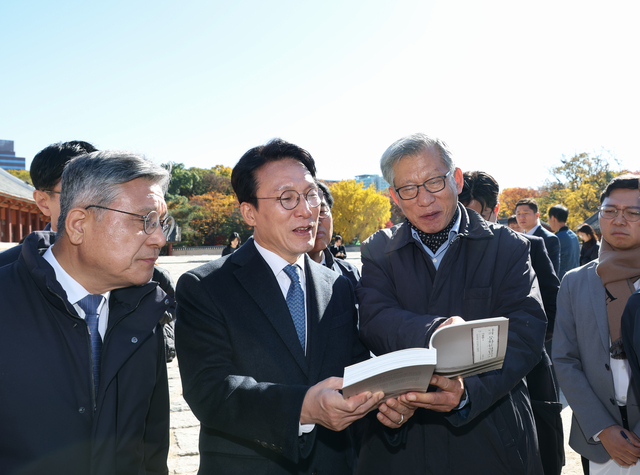 김민석(가운데) 국무총리가 10일 서울시의 종묘 앞 고층건물 허용과 관련해 종로구 종묘를 방문, 유홍준(오른쪽) 국립중앙박물관장과 함께 ‘나의 문화유산답사기’를 펼쳐보고 있다. 연합뉴스