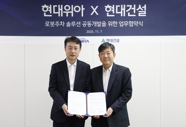 백익진(왼쪽) 현대위아 모빌리티솔루션사업부 상무와 김재영 현대건설 기술연구원 원장이 ‘로봇 친화형 주차솔루션 공동개발을 위한 업무협약식’에서 기념 촬영을 하고 있다. 현대위아 제공