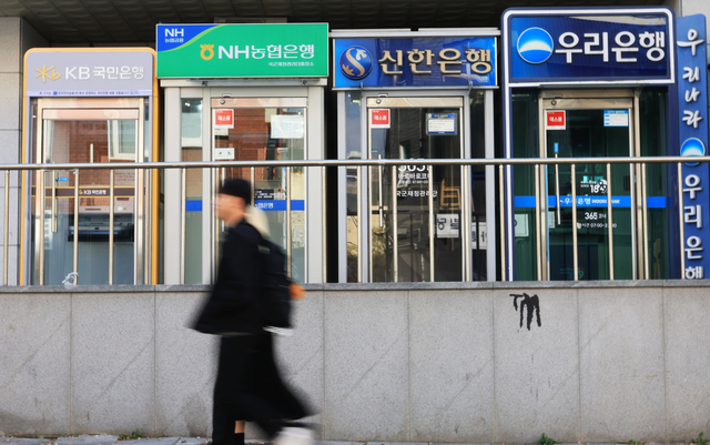 지난 9일 서울 시내에 설치된 은행 ATM기를 시민들이 지나는 모습. 연합뉴스