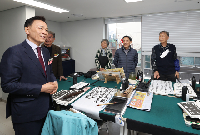 조성명(왼쪽) 서울 강남구청장이 11일 도곡1노인복지관 개관식 후 서예 프로그램 참가자들과 대화하고 있다. 강남구청 제공