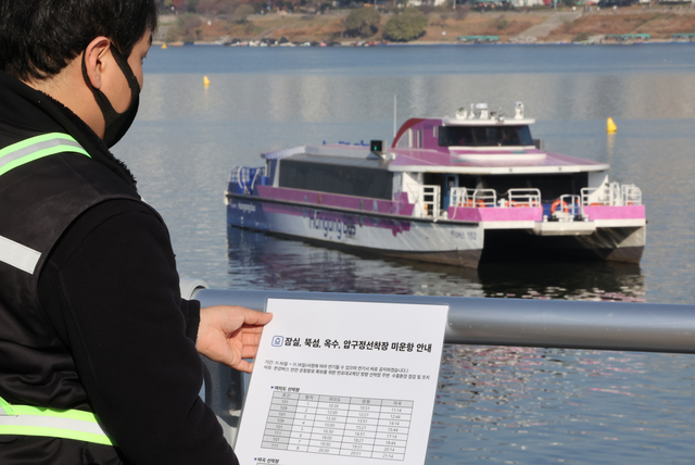 16일 서울 송파구 잠실선착장에서 주변에서 한강버스가 강바닥에 걸려 멈추자 관계자가 운항 중단 안내문을 붙이고 있다. 연합뉴스