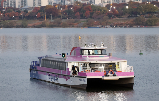 16일 서울 송파구 잠실선착장 부근 강바닥에 걸려 멈춘 한강버스에서 관계자가 수심 확인을 하고 있다. 연합뉴스