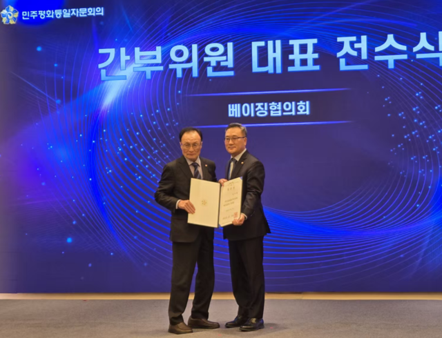 18일 열린 민주평통 22기 베이징협의회 출범식에서 이해찬(왼쪽) 수석부의장이 박기락(오른쪽) 베이징협의회 회장에게 임명장을 전달한 뒤 함께 기념 사진을 찍고 있다.