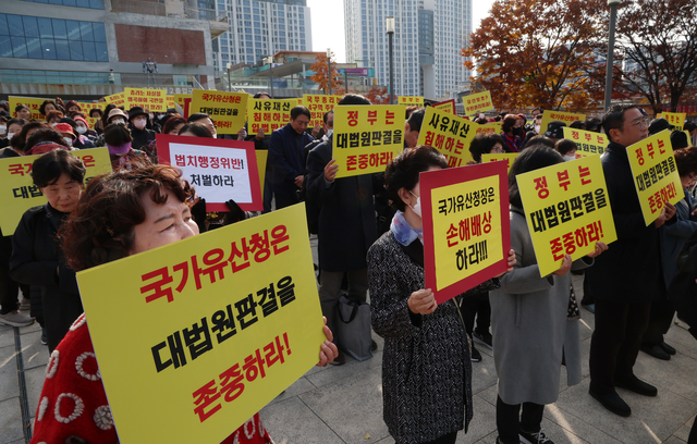 세운4구역주민대표회의 관계자들과 토지주들이 11일 서울 종로구 세운상가 앞 광장에서 국가유산청이 유네스코 세계문화유산인 종묘 인근에 초고층 건물을 세우도록 허가하는 서울시 도시 정비 계획에 대해 우려를 표한 것에 대해 반발하며 구호를 외치고 있다. 뉴시스