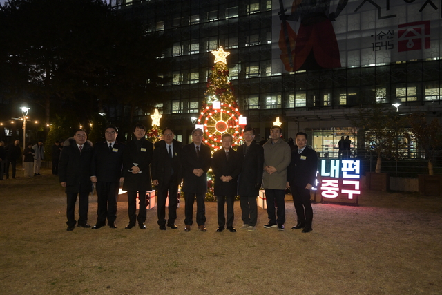 서울 중구청 잔디광장에 마련된 대형 크리스마스 트리 앞에서 지난 2일 김길성 중구청장과 점등식 참석자들이 기념촬영을 하고 있다. 중구청 제공