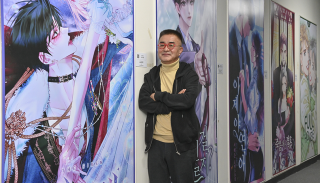 김남철 피플앤스토리 대표가 8일 경남 김해 경남콘텐츠기업지원센터 3층 본사에서 드라마 제작이 예정된 웹툰 작품을 배경으로 포즈를 취하고 있다. 아래 작은 사진은 피플앤스토리의 대표 웹툰 작품인 ‘세이렌’ ‘약 파는 황태자’ ‘사부님들이 구독 중’.  백동현 기자